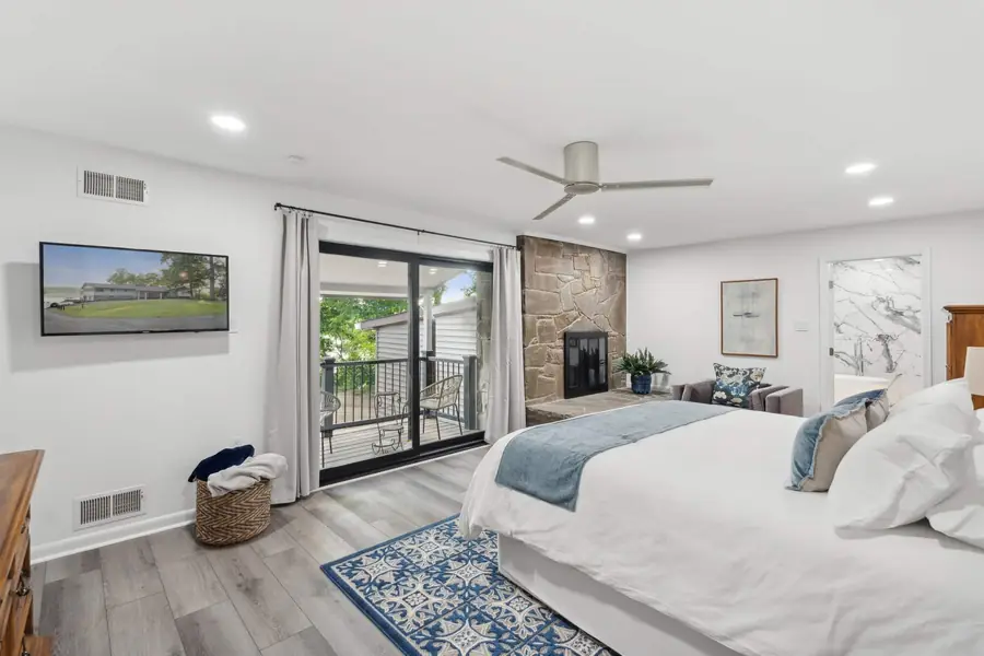 The primary bedroom with a king bed, a fireplace and sliding doors to a balcony