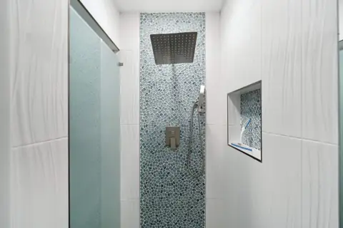 The tiled shower room by the pool and sauna