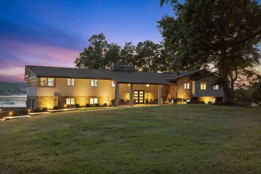 The house glowing at twilight across the lawn