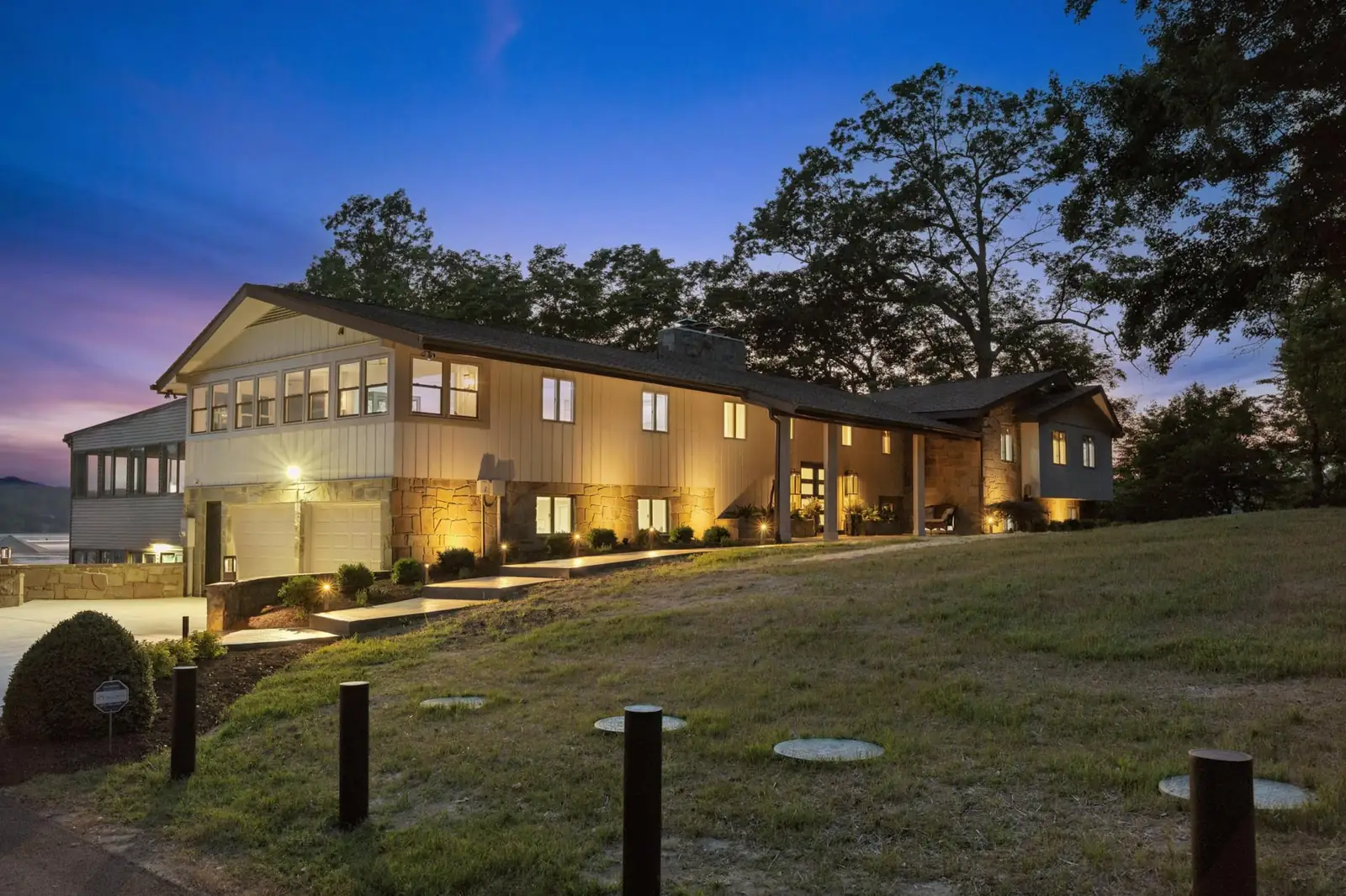 The house at dusk with warm lights along the path